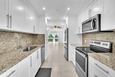 SS appliances, white cabinets, mottled brown granite counters &
