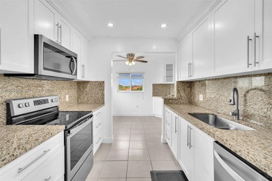 SS appliances, white cabinets, mottled brown granite counters &