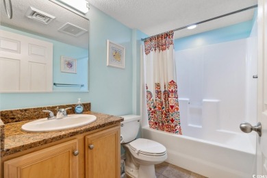 Step right onto the sand from this desirable first-floor, direct