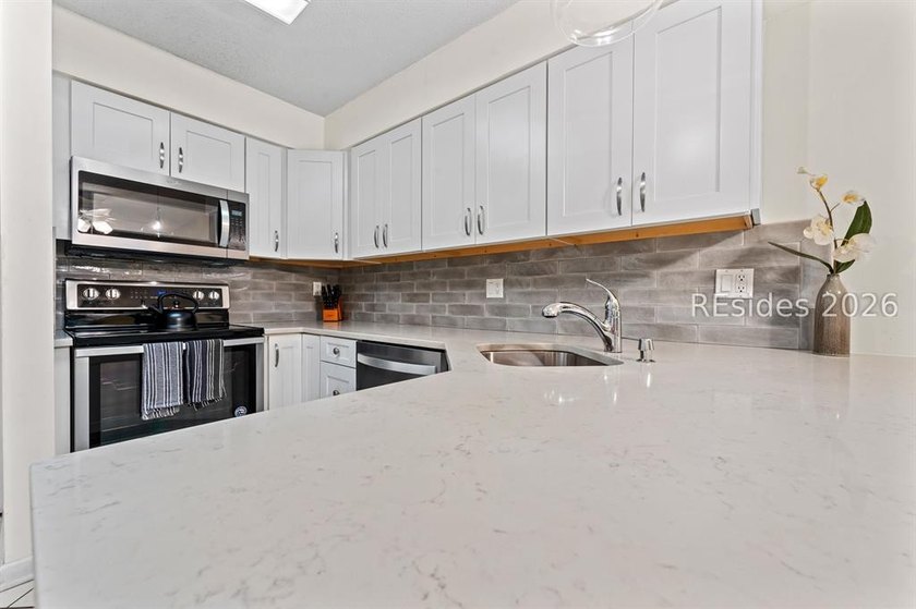 Tucked among mature landscaping in the highly desirable gated - photo 2