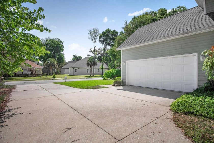 Tucked beneath a canopy of mature trees in the gated community - photo 3