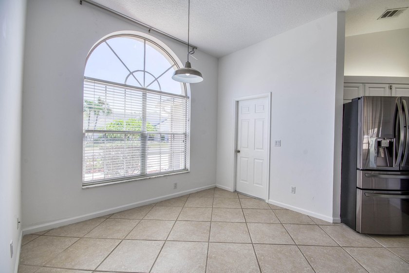 Manicured landscaping and soaring vaulted ceilings welcome you - photo 4