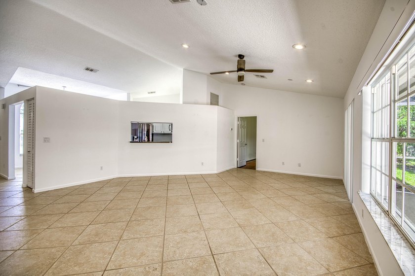 Manicured landscaping and soaring vaulted ceilings welcome you - photo 6