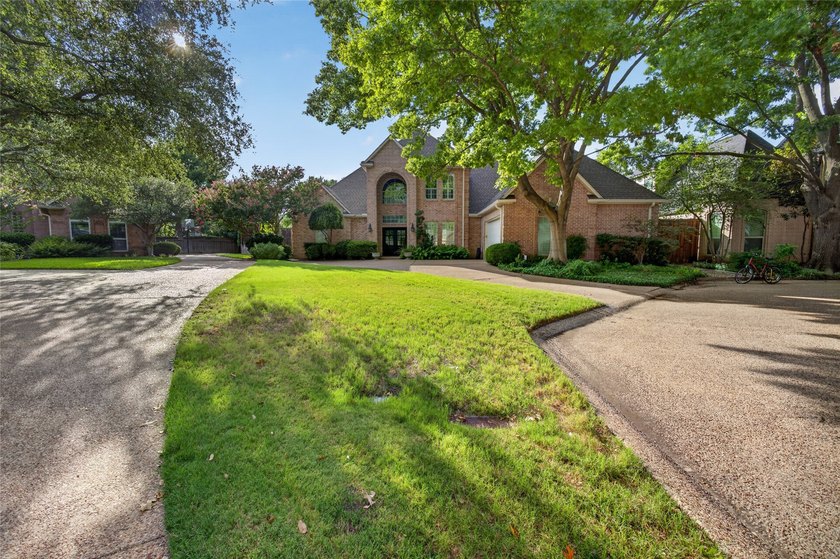 Nestled beneath mature shade trees in the prestigious gated - photo 3