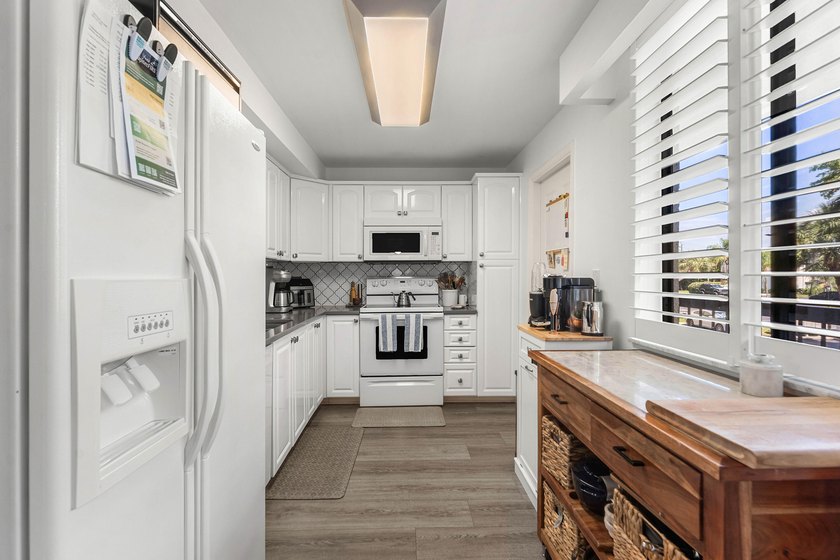 Positioned mere steps from the shoreline, this three-bedroom - photo 11