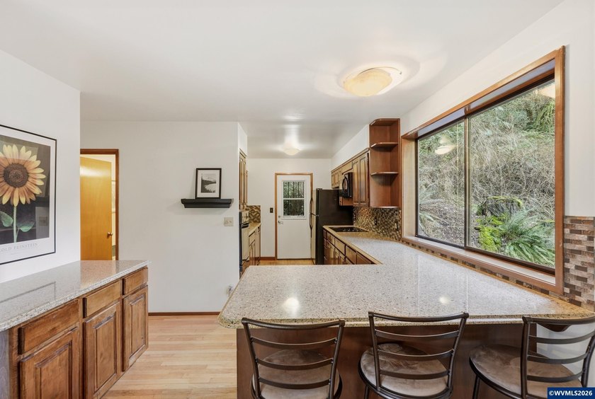 A custom chalet-style home surrounded by natural forest on - photo 6