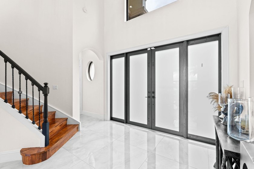 Beyond double entry doors, a remodeled iron staircase frames - photo 23