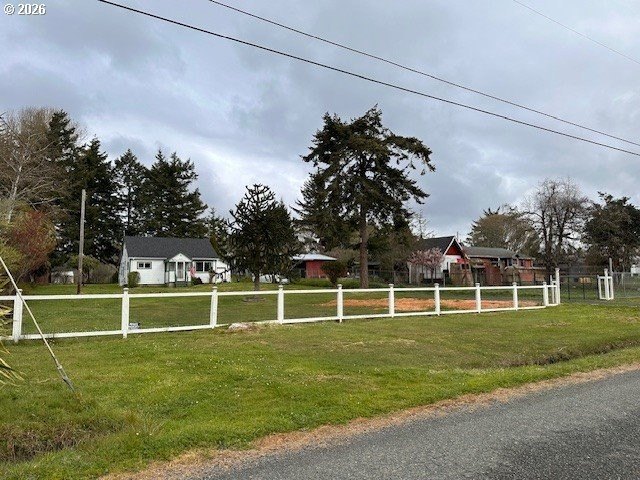 Nearly one-acre level setting with a charming white fence entry - photo 3