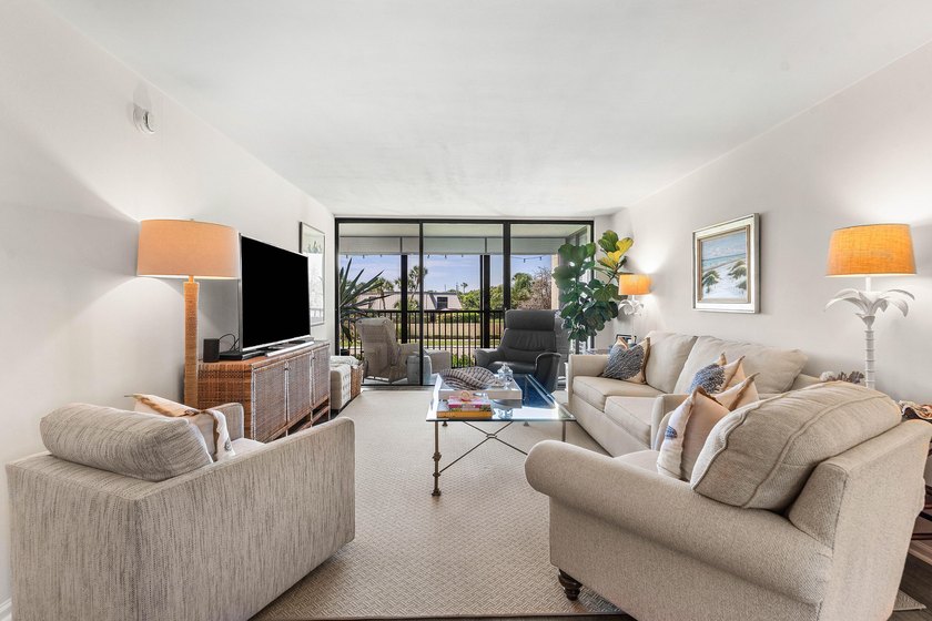 Positioned mere steps from the shoreline, this three-bedroom - photo 3