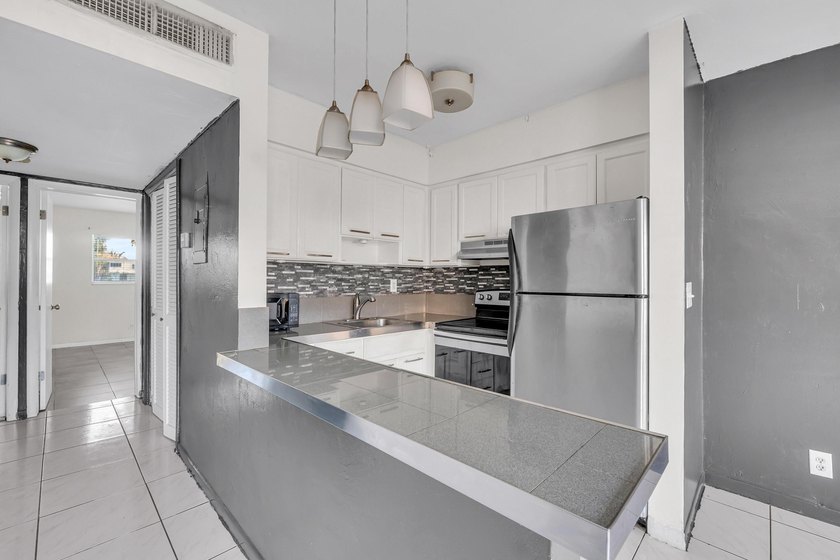 Discover a chic 2-bedroom, 1-bath corner unit condo with - photo 4