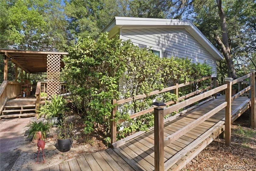 Framed by a canopy of mature trees and lush landscaping, this - photo 4