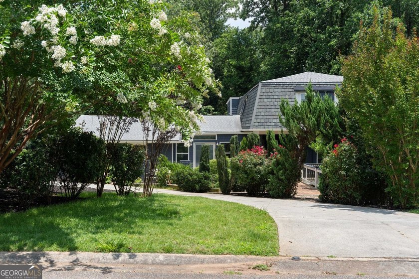 Nestled on a private wooded lot in the highly sought-after - photo 3