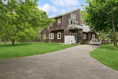 Set on a private 1.18-acre property in Hampton Bays, this - photo 1