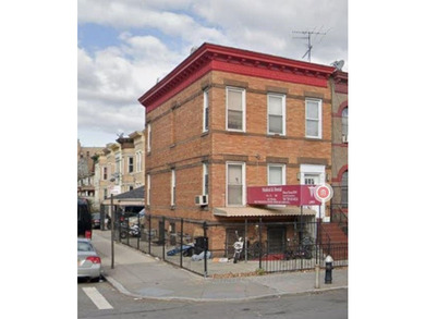 This is a mixed-use brick corner building with a two-car garage - photo 1