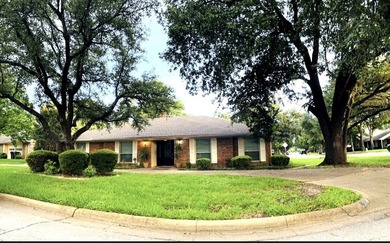 Nestled on a beautifully landscaped corner lot in the - photo 1