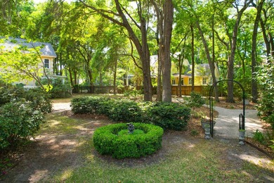 Nestled under mature oak trees and surrounded by gardens, you'll - photo 6