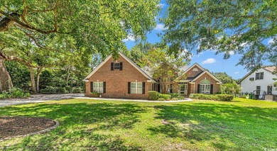 Nestled beneath mature oaks, this custom all-brick home offers a - photo 1
