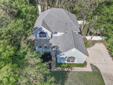 Tucked beneath a canopy of mature trees in the gated community - photo 1