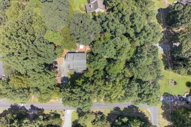 Tucked away on a tree-lined lot with fenced yard, this