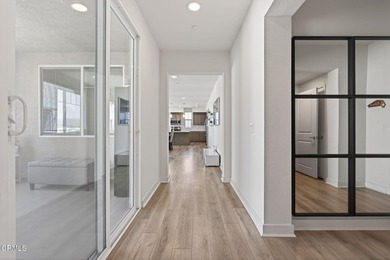 Open-concept living with high ceilings, wide-plank laminate