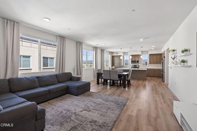 Open-concept living with high ceilings, wide-plank laminate