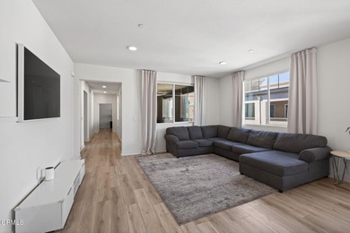 Open-concept living with high ceilings, wide-plank laminate