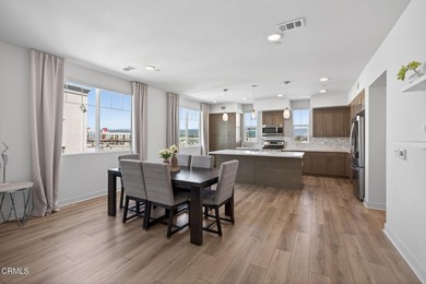 Open-concept living with high ceilings, wide-plank laminate