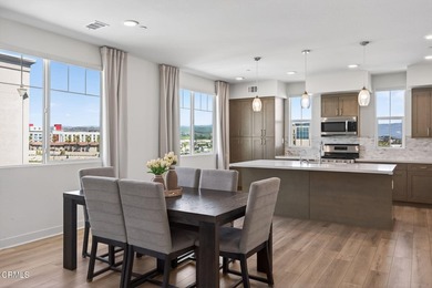 Open-concept living with high ceilings, wide-plank laminate