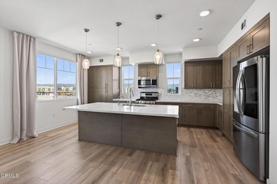 Open-concept living with high ceilings, wide-plank laminate