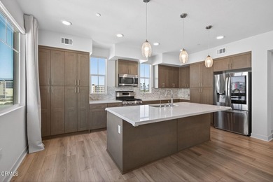 Open-concept living with high ceilings, wide-plank laminate