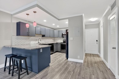 This condominium features an open kitchen, equipped with new - photo 2