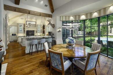 Rising behind a circle drive and flanked by Mediterranean