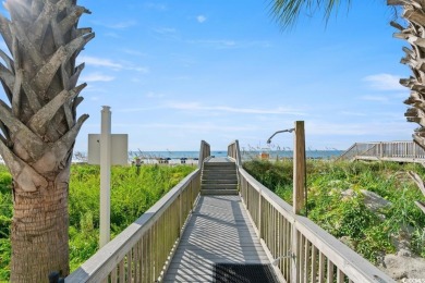 Step right onto the sand from this desirable first-floor, direct