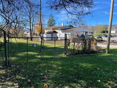 Restaurant building and fenced acreage in the back. Large corner