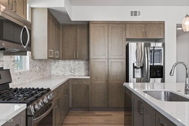 Open-concept living with high ceilings, wide-plank laminate