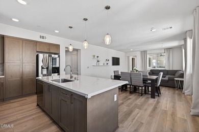 Open-concept living with high ceilings, wide-plank laminate