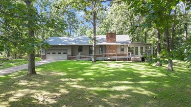 Come home to this charming house nestled in the woods on over an - photo 3