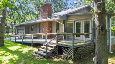 Come home to this charming house nestled in the woods on over an - photo 6