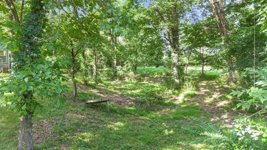 Come home to this charming house nestled in the woods on over an - photo 9