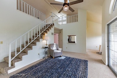 This two-story condo has high vaulted ceilings, skylights, and a - photo 5