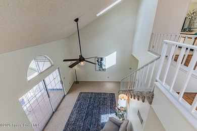 This two-story condo has high vaulted ceilings, skylights, and a - photo 8